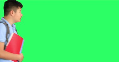Yeşil ekranda sırt çantası olan üzgün bir okul çocuğu.