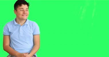 Gülümseyen çocuğun portresi krom anahtar yeşil ekran arkaplanını gösterip alkışlıyor.