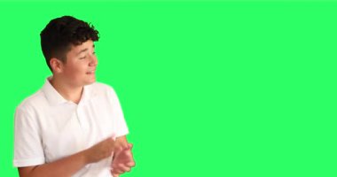 Gülümseyen çocuğun portresi krom anahtar yeşil ekran arkaplanını gösterip alkışlıyor.