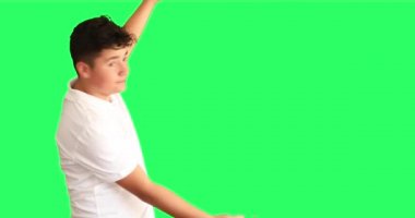 Gülümseyen çocuğun portresi krom anahtar yeşil ekran arkaplanını gösterip alkışlıyor.