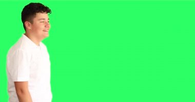 Genç çocuk yeşil ekrana bakıp gülüyor.