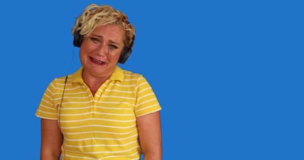 Portret Blondynki Średnim Wieku Słuchawką Słuchającą Muzyki Płaczącą Tle Niebieskiego — Wideo stockowe