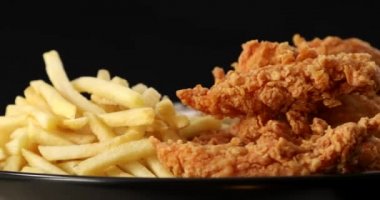 Lezzetli patates kızartması ve hardallı çıtır tavuk nugget ve siyah üzerine ketçap.