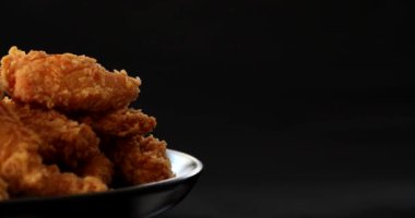 Lezzetli patates kızartması ve hardallı çıtır tavuk nuggetları ve siyah arka planda ketçap.