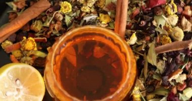 Bir fincan sağlıklı çay, farklı türde kurutulmuş otlar ve çiçekler.