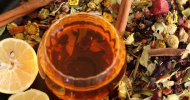 Bir fincan sağlıklı çay, farklı türde kurutulmuş otlar ve çiçekler.