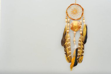 Yakın plan detaylar, gri arka planda altın renkli tüyleri olan modern düş kapanı.