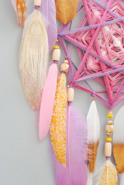 Mandala düş kapanı, gri arka planda pembe altın tüylü.