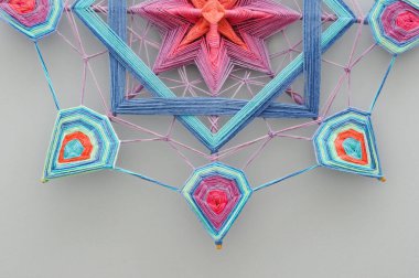 Gri arkaplanda örülmüş renkli el yapımı iplik mandala