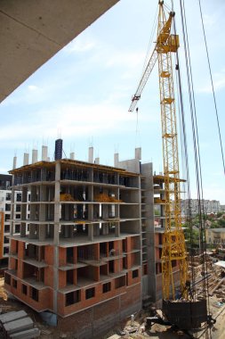 Yeni modern bir bina. Evin inşaat çalışma crane. Şantiye ile gökyüzü arka plan üzerinde Vinçler. 