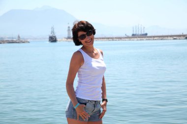 Güzel kız deniz arka plan üzerinde kamera için poz.