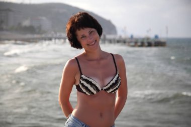 Güzel kız deniz arka plan üzerinde kamera için poz. Model yaz gün sahilde poz.