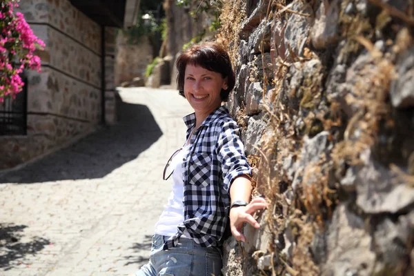 Bir kız bir eski şehir sokak kaldırım taşları ile döşeli bir kamera için poz. Sokak. Sanat güzel eski şehir Alanya