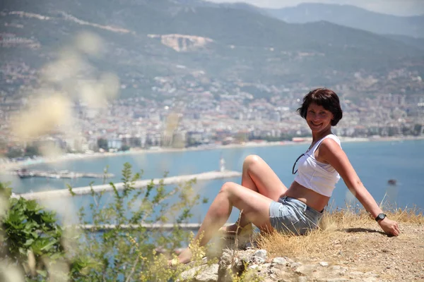 Güzel kız deniz arka plan üzerinde kamera için poz. 