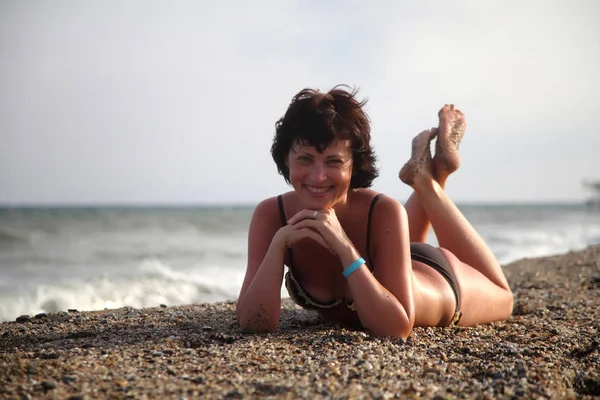 Güzel kız deniz arka plan üzerinde kamera için poz. Model yaz gün sahilde poz.