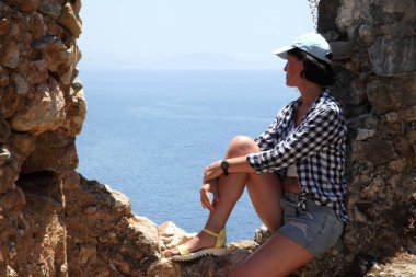 Alanya Alanya Yarımadası limandan görünümü. Türkiye sahillerinde. Güzel kız deniz arka plan üzerinde kamera için poz. Model yaz gün sahilde poz.