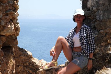 Alanya Alanya Yarımadası limandan görünümü. Türkiye sahillerinde. Güzel kız deniz arka plan üzerinde kamera için poz. Model yaz gün sahilde poz.