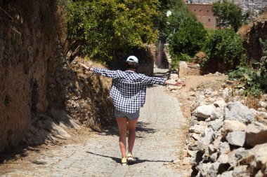 Bir kız bir eski şehir sokak kaldırım taşları ile döşeli bir kamera için poz. Sokak. Sanat güzel eski şehir Alanya