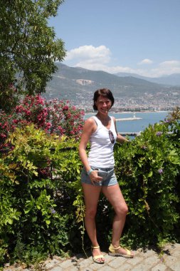 Alanya Alanya Yarımadası limandan görünümü. Türkiye sahillerinde. Güzel kız deniz arka plan üzerinde kamera için poz. Model yaz gün sahilde poz.