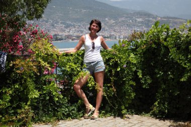 Alanya Alanya Yarımadası limandan görünümü. Türkiye sahillerinde. Güzel kız deniz arka plan üzerinde kamera için poz. Model yaz gün sahilde poz.