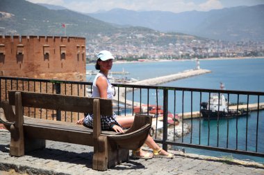 Alanya Alanya Yarımadası limandan görünümü. Türkiye sahillerinde. Güzel kız deniz arka plan üzerinde kamera için poz. Model yaz gün sahilde poz.