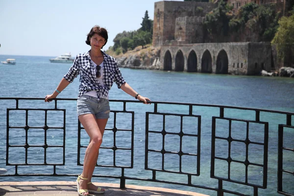 A girl is posing for a camera in an old city street paved with paving stones. Street. Art beautiful old town of Alanya