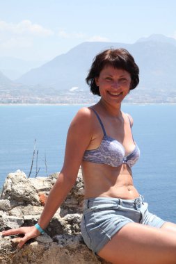 Alanya Alanya Yarımadası limandan görünümü. Türkiye sahillerinde. Güzel kız deniz arka plan üzerinde kamera için poz. Model yaz gün sahilde poz.