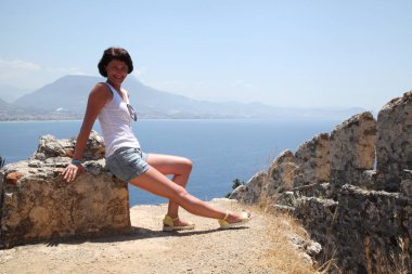 Alanya Alanya Yarımadası limandan görünümü. Türkiye sahillerinde. Güzel kız deniz arka plan üzerinde kamera için poz. Model yaz gün sahilde poz.