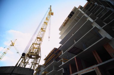 Konut çok katlı bina inşaatı. Yeni yerleşim bölgesi. Evin inşaat çalışma crane. Şantiye ile gökyüzü arka plan üzerinde Vinçler. 