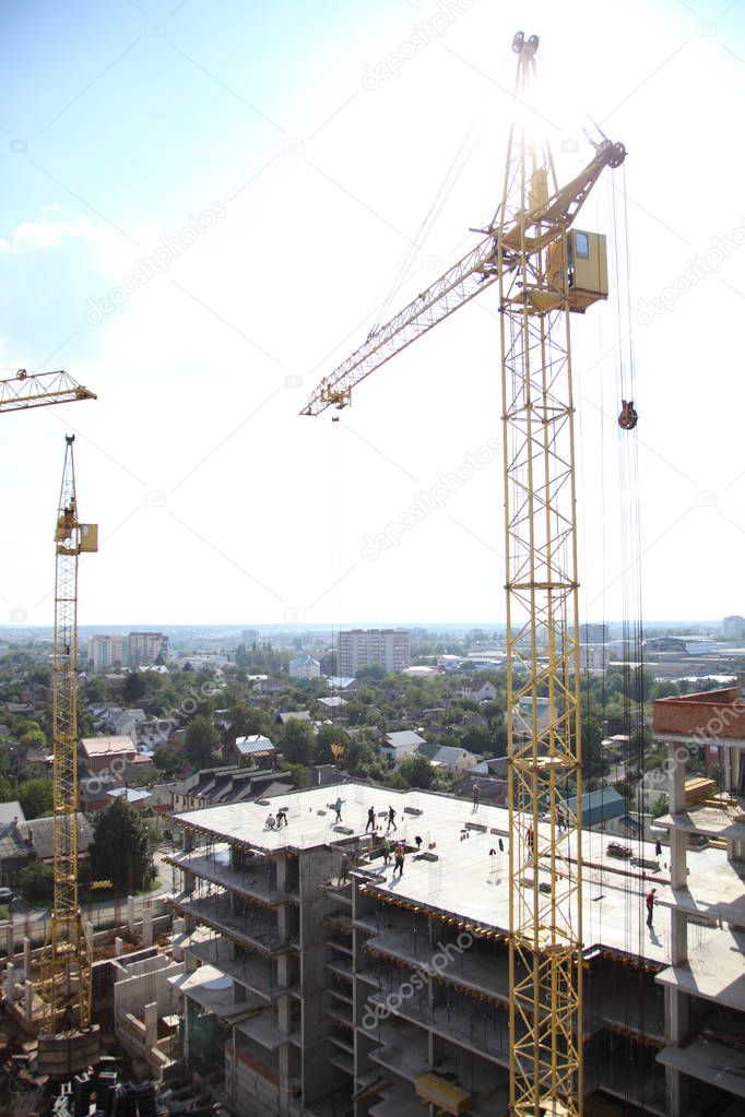 Working crane on the construction of the house. Construction of a residential multi-storey building. New residential area. 