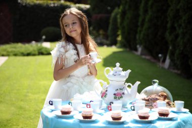 Küçük Alice çay içiyor.