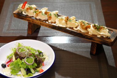 Bir tahta ve salata üzerinde ekşi krema patates ve greaves ile Köfte. Patates ve salata ile Köfte.