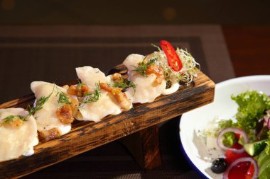 Bir tahta ve salata üzerinde ekşi krema patates ve greaves ile Köfte. Patates ve salata ile Köfte.