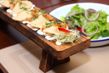 Bir tahta ve salata üzerinde ekşi krema patates ve greaves ile Köfte. Patates ve salata ile Köfte.