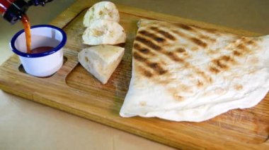 Orta pişmiş biftek, ahşap bir tahtanın üzerinde sos ve baharatlarla dilimlenmiş. Lezzetli biftek. Sebze yastığında az pişmiş biftek. Tahta tabakta biftek..