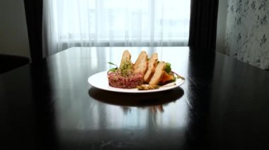 Baharatlı, kızarmış ekmek ve otlu çiğ tartar eti. Kaparili biftek tartartarı. Ekmek dilimli biftek tartartarı. Gurme et için çiğ et..