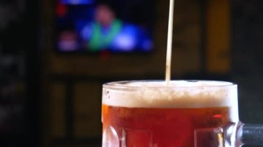 Bira barı. Barmen bardağa bira doldurur..