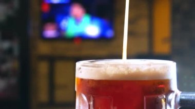 Bira barı. Barmen bardağa bira doldurur..