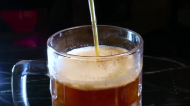 Bira barı. Barmen bardağa bira doldurur..