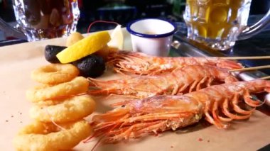 Bira barı. Langoustine ve bira. Bira ve deniz ürünleri atıştırmalıkları. Langoustine, bira, mürekkep balığı halkaları.. 