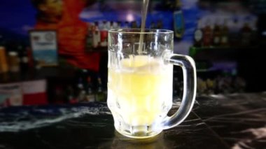 Bira barı. Barmen bardağa bira doldurur..