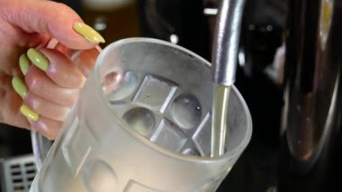 Bira barı. Barmen bardağa bira doldurur..