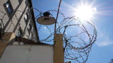 Eski hapishane. Hapis. Dikenli tel. Metal dikenli çitli beyaz duvar.
