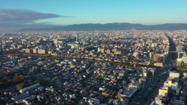 Japonya 'nın Kyoto şehrinde ufuk çizgisi manzaralı Kyoto binalarının 4k hava görüntüsü. sabah.
