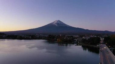 Japonya 'nın Kawaguchi Gölü' nde güneş doğarken Fuji Dağı ve köprüsünün 4k hava görüntüsü..