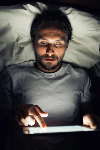 Young handsome and tired man with a beard cannot sleep and is wa Stock Photo