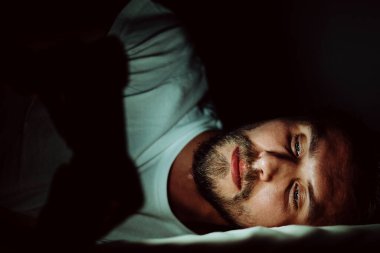 Genç ve mutlu bir adam uyuyamıyor ve doktorasından bir şeyler izliyor.