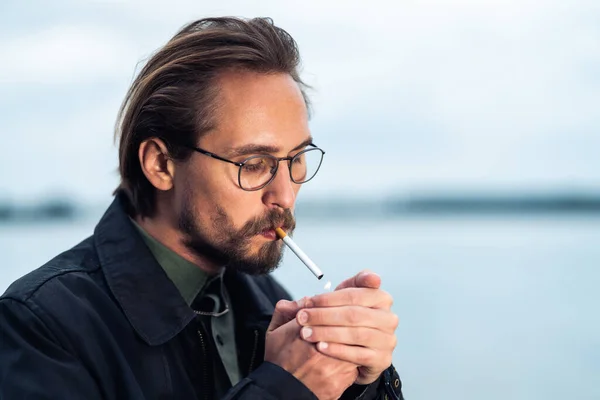 Young handsome man lighting up cigarette — Stock Photo, Image