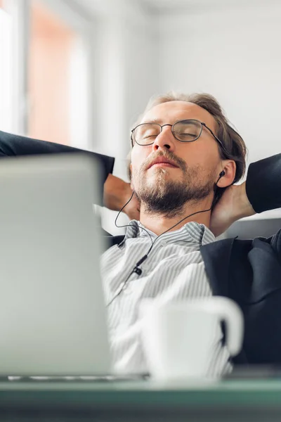 Young man is trying to relax and sleep while listening to music Royalty Free Stock Images