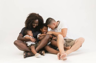 Mikser yarış aile 2 çocuklu yere oturma. Mutlu çift izole iki oğlu ile oturuyor. Babası gıdıklama çocuk.